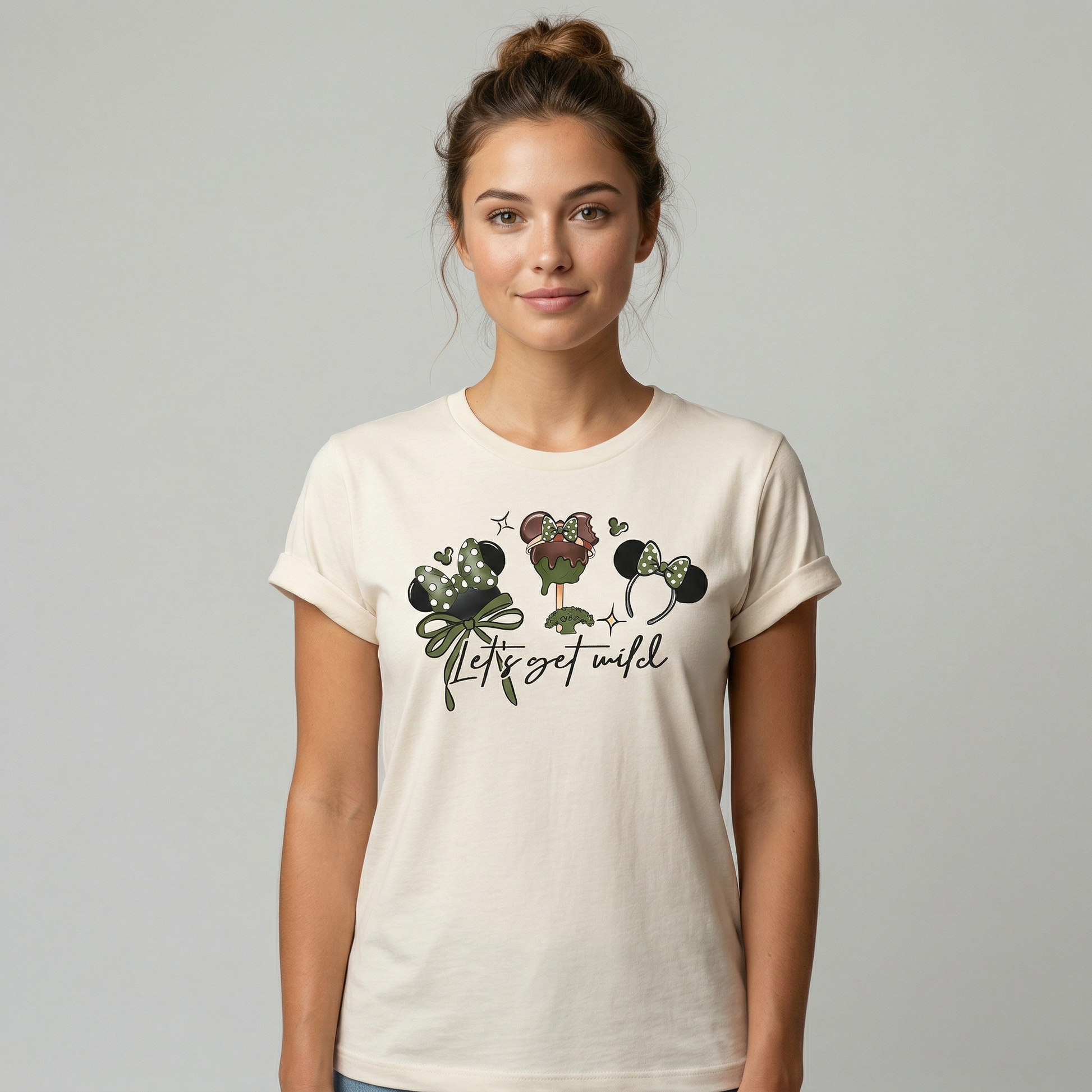 Woman wearing a cream t-shirt with Disney graphic design with the text "Let's get wild" on a plain back ground 