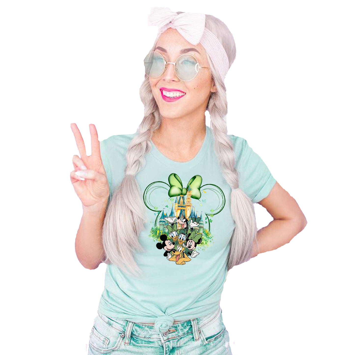 Person wearing a Mint Green t-shirt with Disney St. Patrick Day-themed Mickey Mouse, Minnie Mouse,Donald Duck, Daisy Duck, Goofy in front of cinderella castle with minnie outline head with green bow graphic  making a peace sign.