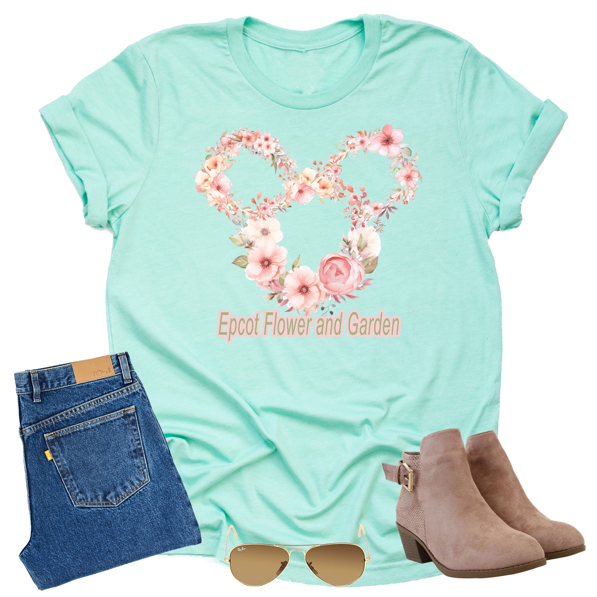 Model wearing short-sleeved unisex t-shirt in a mint color, featuring floral graphics arranged in the shape of mickey with the Epcot logo with the text 'Epcot Flower and Garden' on the front.