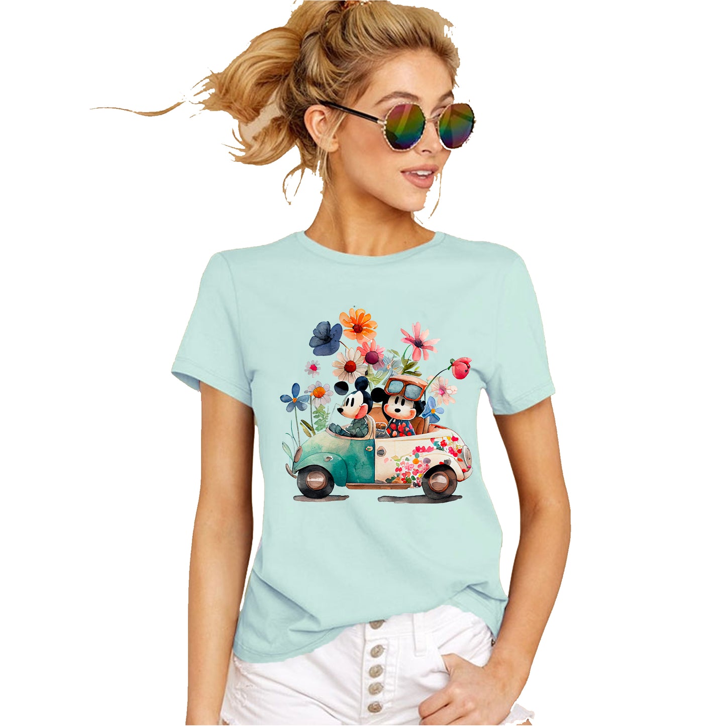 A women wearing mint-colored unisex t-shirt featuring an illustration of Mickey and Minnie Mouse sitting a Volkswagen in garden attire, surrounded by floral elements and a whimsical design.